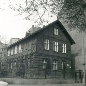 budynek drewniano-ceglany, otoczony płotem