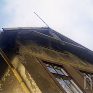 fragment szczytowej ściany budynku z dwoma oknami zakończony dwuspadowym dachem