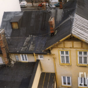 widok z lotu ptaka na budynek mieszkalny z przybudówką, dwoma kominami i spadzistym dachem