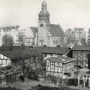 dwukondygnacyjne domy drewniano-murowane, w głębi kościół z wieżą