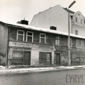 zaniedbane, dwukondygnacyjne proste budynki stojące przy brukowanej ulicy