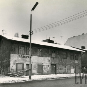 zaniedbane, dwukondygnacyjne proste budynki stojące przy brukowanej ulicy