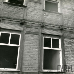 fragment ściany drewniano-ceglanego budynki, okna pozbawione szyb i częściowo ram okiennych