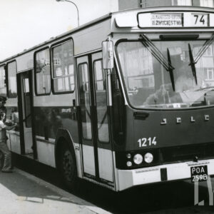 przystanek autobusowy, przód i bok autobusu Jelcz, do którego wsiada kobieta z dwójką dzieci