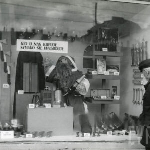 witryna z narzędziami, w środku kukła ze słomy