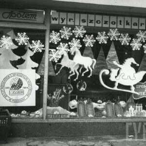 dekoracja w oknie wystawionymi koszykami z wikliny oraz sylwetką św. Mikołaja w saniach, ciągniętych przez konie, papierowe gwiazdki