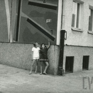 dwie dziewczynki stojące pod blokiem z wielkiej płyty