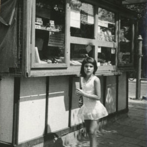 dziewczynka w białej sukience na tle kiosku