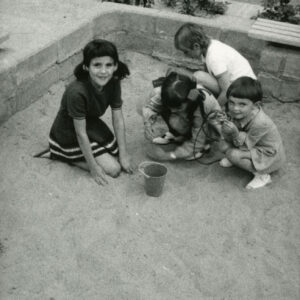 czworo dzieci kucających, robiących babki z piasku