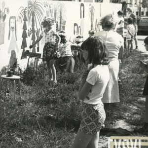 grupa dzieci malujących po płocie