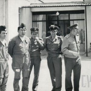 grupa mężczyzn w mundurach wojskowych, w głębi budynek