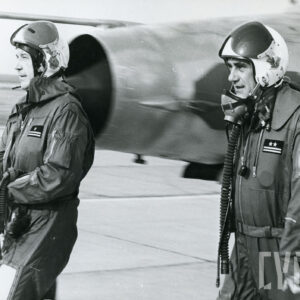 dwóch mężczyzn w wojskowych kombinezonach lotniczych na tle samolotu wojskowego 