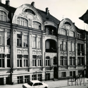 czterokondygnacyjna kamienica z poddaszem z bogato zdobioną dekoracją rzeźbiarską na fasadzie