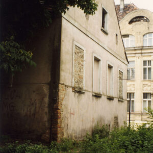 budynek z odpadającym tynkiem, skośnym dachem