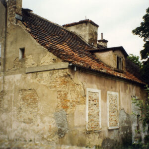 budynek z zamurowanymi oknami, na ścianach odpadający tynk