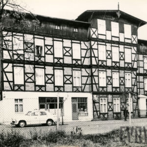 czterokondygnacyjny, drewniano-ceglany budynek z drewnianym poddaszem