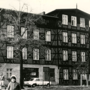 czterokondygnacyjny, drewniano-ceglany budynek z drewnianym poddaszem