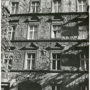 fragment elewacji czterokondygnacyjnej kamienicy z bogatą dekoracją rzeźbiarską