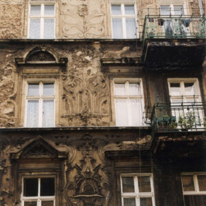 fragment elewacji czterokondygnacyjnej kamienicy z bogatą dekoracją rzeźbiarską