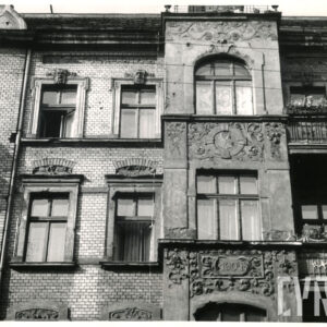 fragment elewacji kilkukondygnacyjnej kamienicy z bogatą dekoracją rzeźbiarską