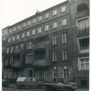 czteropiętrowa kamienica, przed nią zaparkowane samochody