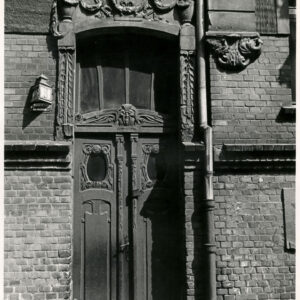 drewniane drzwi nad nimi bogata dekoracja rzeźbiarska