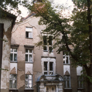 trzykondygnacyjny budynek z ozdobnym portalem i szczytem oraz wieżyczką