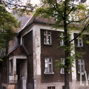 dwukondygnacyjny budynek, dookoła niego drzewa