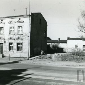 na pierwszym planie jednopiętrowy murowany, otynkowany budynek mieszkalny, z prawej w głębi niski budynek murowany