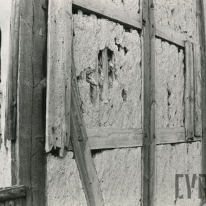 fragment szachulcowej ściany z widocznymi ubytkami gliny wypełniającej drewniany szkielet