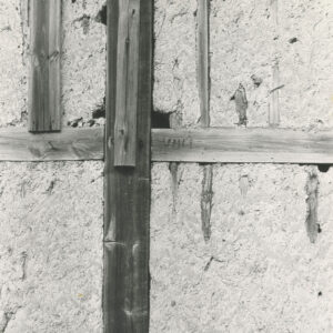 fragment szachulcowej ściany z widocznymi ubytkami gliny wypełniającej drewniany szkielet