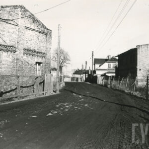 bita, rozjechana ulica z ceglanymi domami po obu stronach