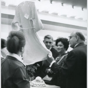 grupa mężczyzn i kobiet ogląda sukienkę