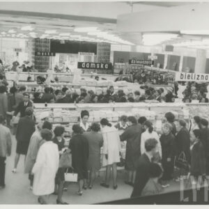 wnętrze dużego sklepu, półki z towarami, między nimi klienci