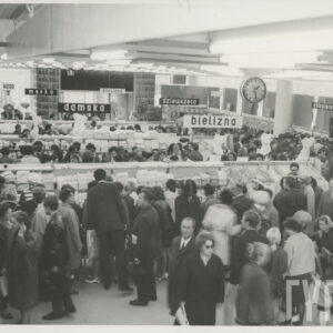 wnętrze dużego sklepu, półki z towarami, między nimi klienci