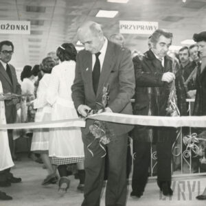 na pierwszym planie mężczyzna przecina wstęgę, za nim duża grupa ludzi