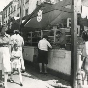 stoiska drewniane, przy nim ludzie