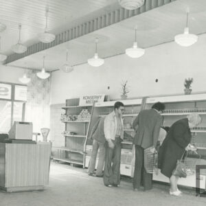 wnętrze dużego sklepu, w głębi, przy ścianie lady chłodnicze, przy nich klienci, z lewej kasa