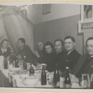 grupa kobiet i mężczyzn siedzi przy zastawionym stole