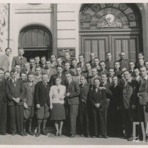 duża grupa ludzi pozuje do zdjęcia przed wejściem do budynku