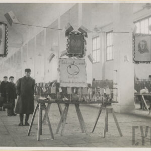 hala wystawowa, pośrodku oraz po bokach ustawione klatki, z lewej zwiedzający w płaszczach