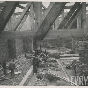 wnętrze budowanego pawilonu, ceglane ściany, drewniana konstrukcja dachu, pracujący robotnicy