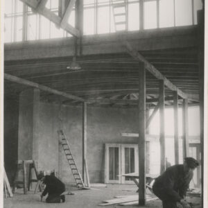 wnętrze budowanego pawilonu, murowane ściany, drewniana konstrukcja dachu, pracujący robotnicy