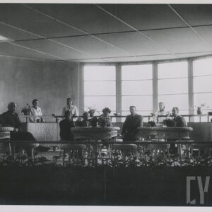 wnętrze z dużym oknem na półokrągłej ścianie, na krzesłach, przy stolikach siedzą ludzie