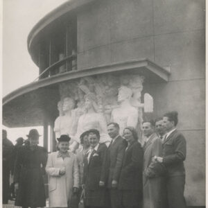 grupa kobiet i mężczyzn pozuje na zdjęciach, przed pawilonem, przy wejściu do pawilonu płaskorzeźba