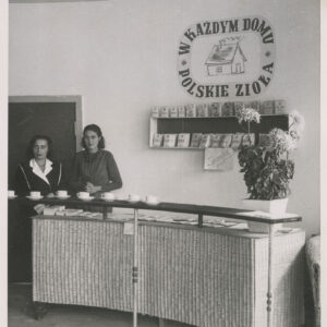 dwie kobiety stoją za ladą, na niej stoją filiżanki, na ścianie napis „w każdym domu polskie zioła”