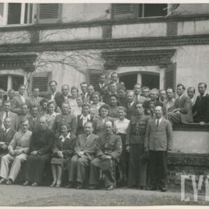 grupa ludzi na tle stylizowanego budynku