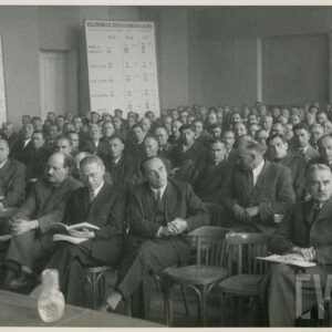 w równych rzędach, w dużej sali na krzesłach siedzą mężczyźni