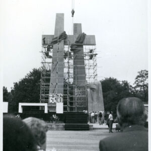 stalowa krzyże otoczone rusztowaniem, pod krzyżami grupa przyglądających się ludzi