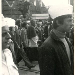 grupa ludzi, w tym osoby duchowne, w pochodzie ulicą